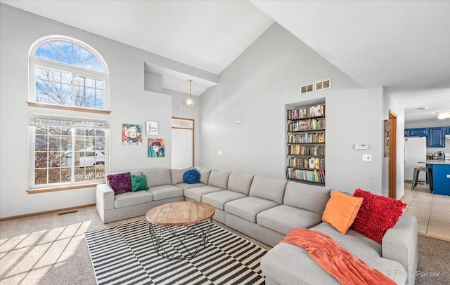living room with light colored carpet, high vaulted ceiling, and visible vents