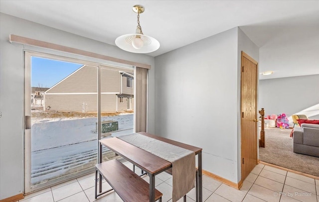 dining area with baseboards and light tile patterned flooring