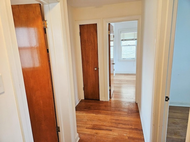 hall featuring baseboards and wood finished floors