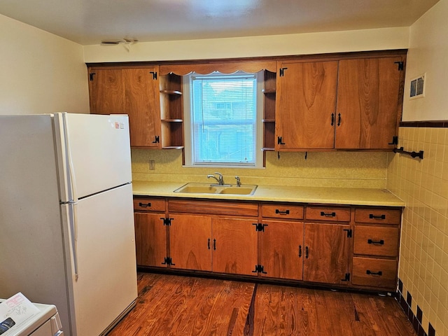 kitchen featuring visible vents, tile walls, open shelves, a sink, and freestanding refrigerator
