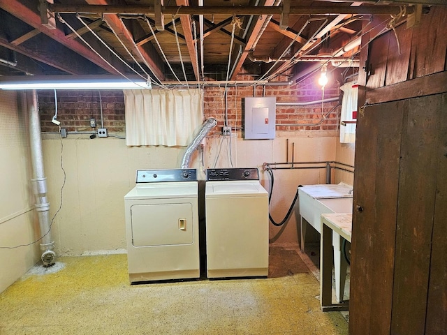 washroom featuring separate washer and dryer, laundry area, a sink, and electric panel