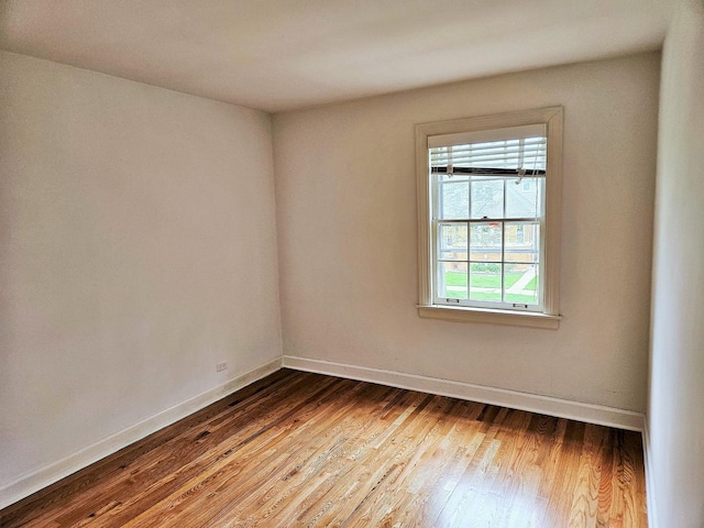 empty room with baseboards and wood finished floors