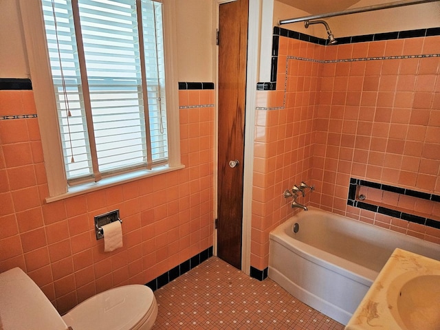 full bathroom featuring toilet, tile walls, shower / washtub combination, and tile patterned flooring