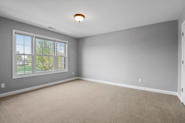 carpeted empty room featuring baseboards and visible vents