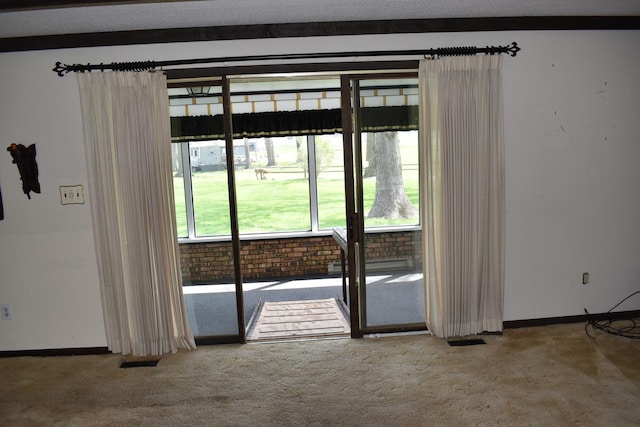 doorway to outside featuring carpet floors, baseboards, and visible vents