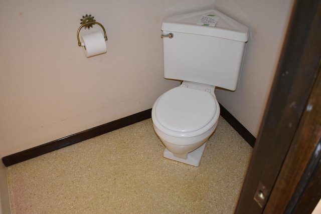 bathroom with baseboards and toilet