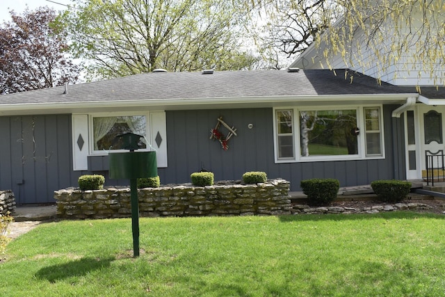 single story home with roof with shingles, board and batten siding, and a front lawn