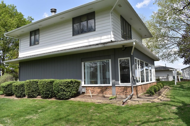 view of home's exterior featuring a lawn and brick siding