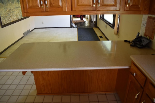 kitchen featuring light countertops, brown cabinets, and visible vents