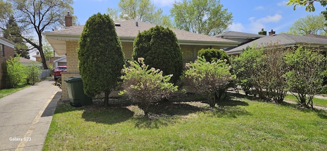 view of property exterior featuring a chimney and a lawn