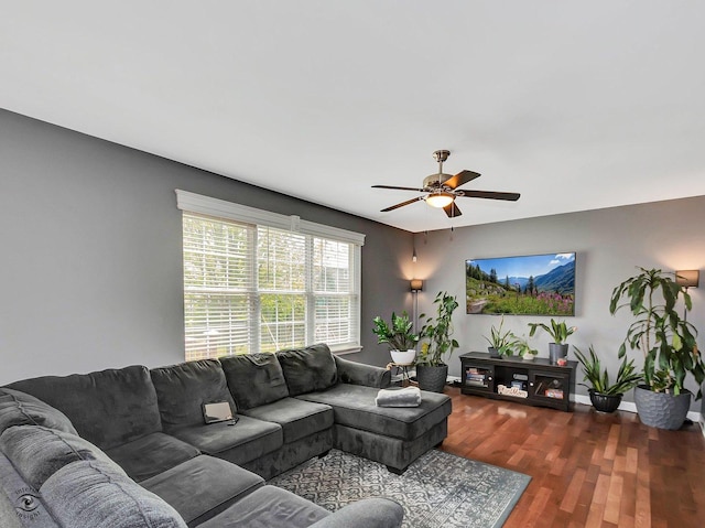 living area with baseboards, ceiling fan, and wood finished floors