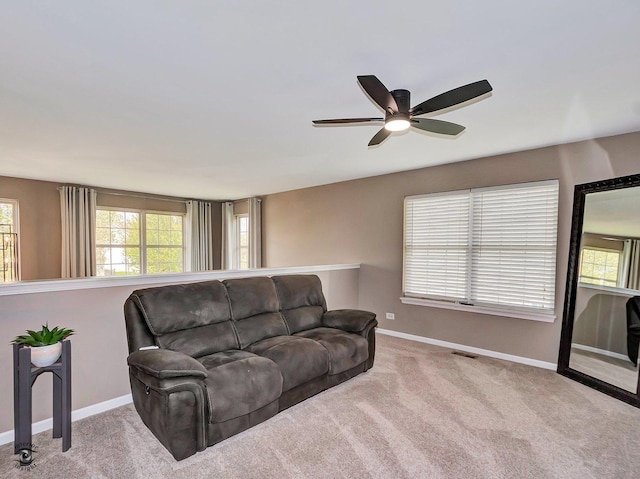 living area with carpet floors, baseboards, ceiling fan, and visible vents