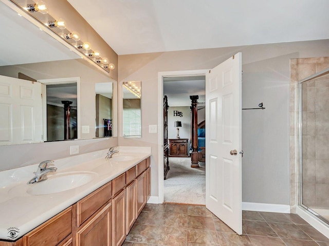 ensuite bathroom with a sink, baseboards, a stall shower, and double vanity