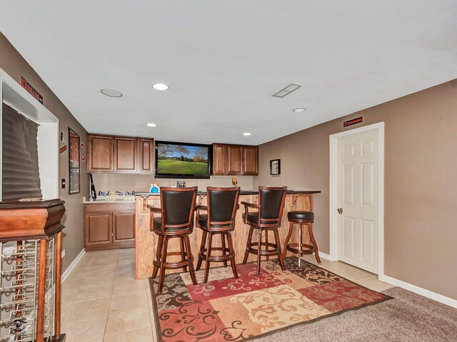 bar featuring baseboards, recessed lighting, wet bar, and light tile patterned floors