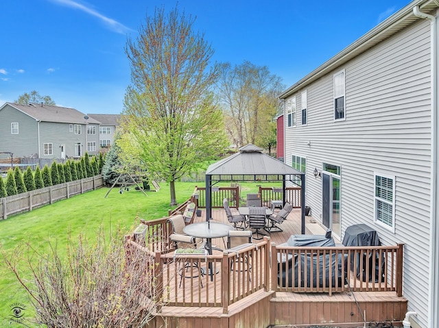 deck featuring fence, outdoor dining space, a gazebo, grilling area, and a yard
