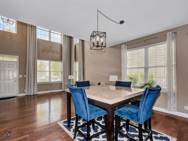 dining area featuring baseboards, dark wood-style floors, and a chandelier