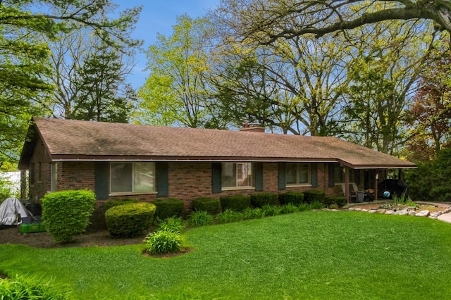 257 Banbury Rd, Mundelein, IL 60060 - ranch-style house featuring a shingled roof, a front lawn, a chimney, and brick siding