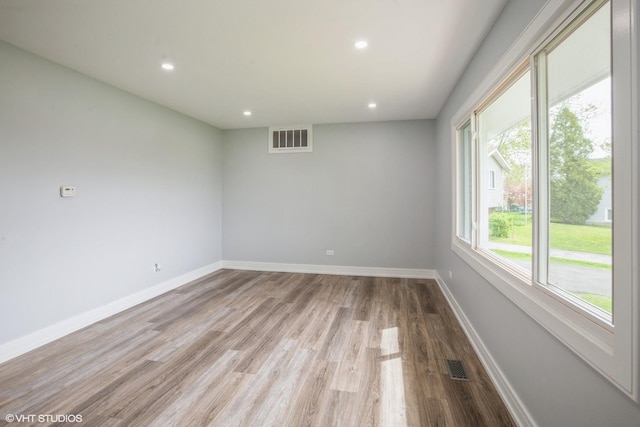 spare room with recessed lighting, baseboards, visible vents, and wood finished floors