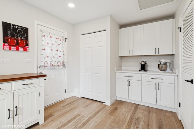 kitchen with butcher block countertops, baseboards, light wood-type flooring, recessed lighting, and white cabinetry