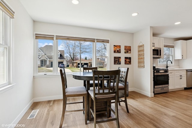 dining area featuring visible vents, baseboards, plenty of natural light, and light wood-style floors