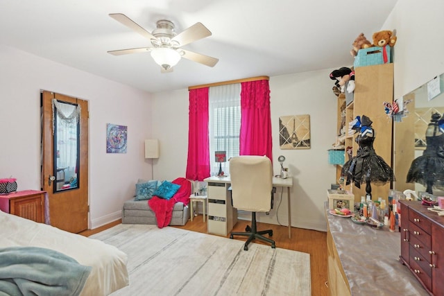 bedroom featuring baseboards, a ceiling fan, and wood finished floors