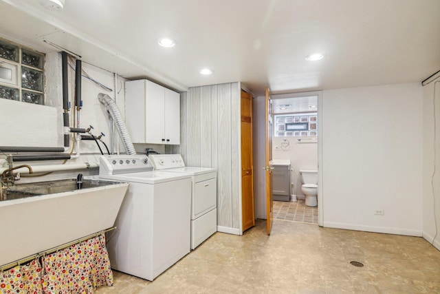laundry room featuring cabinet space, a sink, recessed lighting, baseboards, and washer and clothes dryer