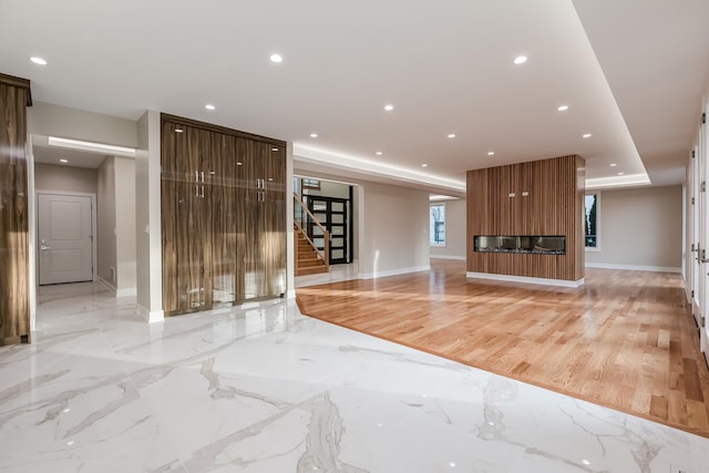 616 Glendale Rd, Glenview, IL 60025 - unfurnished living room featuring a large fireplace, stairway, baseboards, a tray ceiling, and recessed lighting