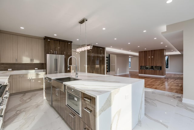 616 Glendale Rd, Glenview, IL 60025 - kitchen with light stone countertops, appliances with stainless steel finishes, a sink, marble finish floor, and modern cabinets