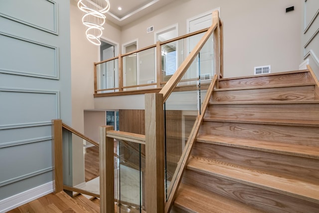 616 Glendale Rd, Glenview, IL 60025 - stairs with a chandelier, wood finished floors, and visible vents