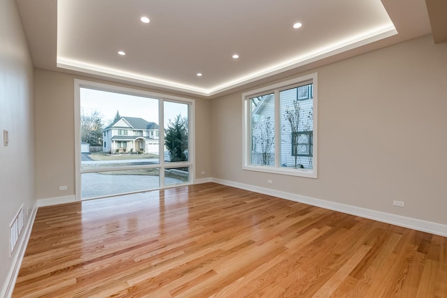 616 Glendale Rd, Glenview, IL 60025 - spare room featuring visible vents, a tray ceiling, and light wood-type flooring