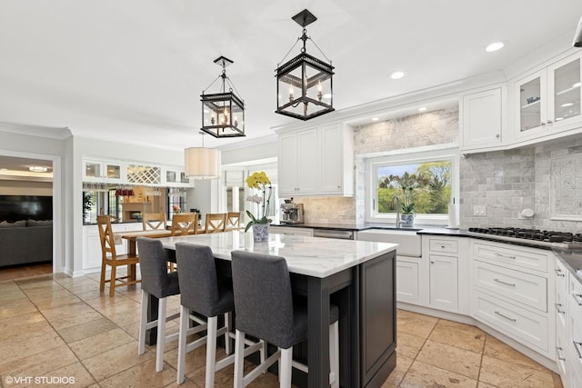 30 Rue Foret, Lake Forest, IL 60045 - kitchen with stone tile floors, decorative backsplash, a sink, white cabinets, and crown molding