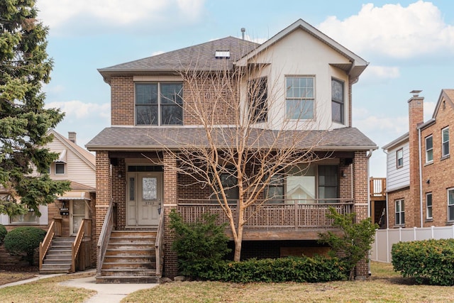 traditional home featuring brick siding, fence, and a shingled roof