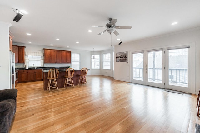 living area with ceiling fan, crown molding, baseboards, light wood-style floors, and recessed lighting