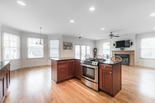 kitchen with a fireplace, recessed lighting, light wood-type flooring, and gas range
