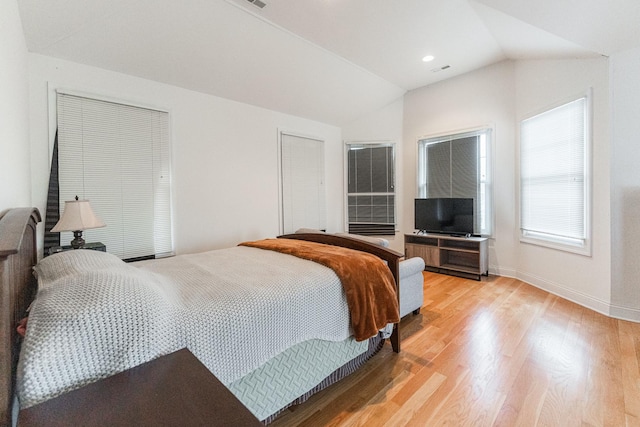 bedroom featuring light wood-type flooring, baseboards, and lofted ceiling