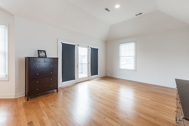unfurnished bedroom with visible vents, lofted ceiling, light wood finished floors, and access to exterior