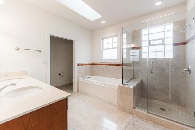 full bathroom with a shower stall, a sink, and a garden tub