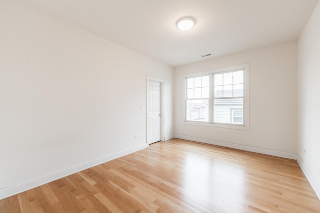 empty room with baseboards, visible vents, and light wood-style flooring
