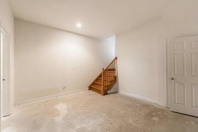 basement featuring stairway, baseboards, and recessed lighting