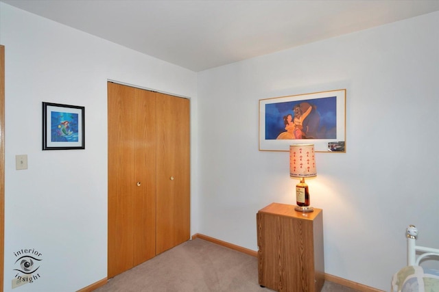 carpeted bedroom featuring baseboards and a closet