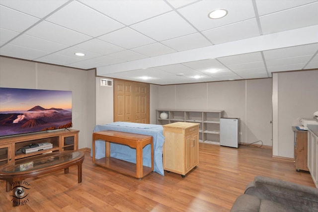 living area featuring light wood-style floors, a paneled ceiling, recessed lighting, baseboards, and visible vents