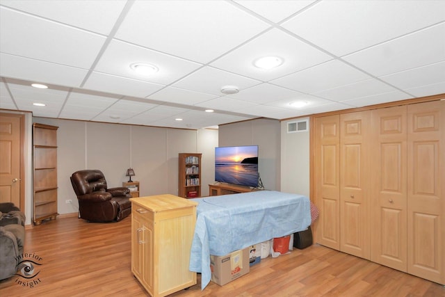 living area featuring recessed lighting, light wood-type flooring, a paneled ceiling, and visible vents