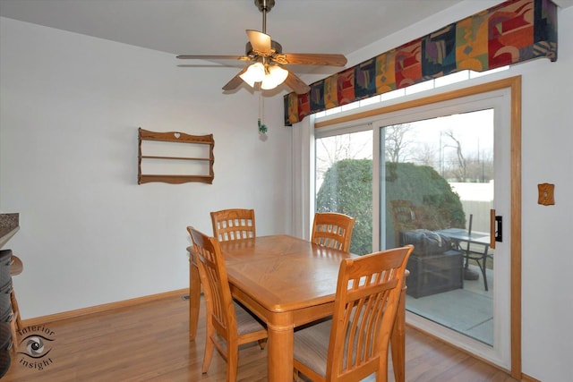 dining room with a ceiling fan, baseboards, and light wood-style floors