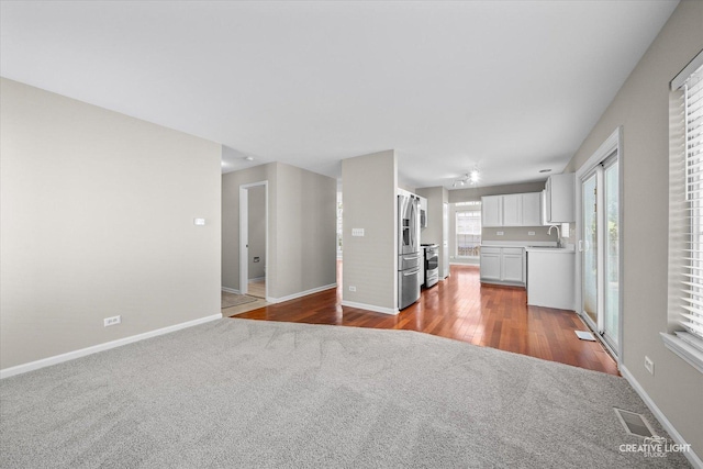 1207 Pennsbury Ln, Aurora, IL 60502 - unfurnished living room featuring carpet, a sink, and baseboards