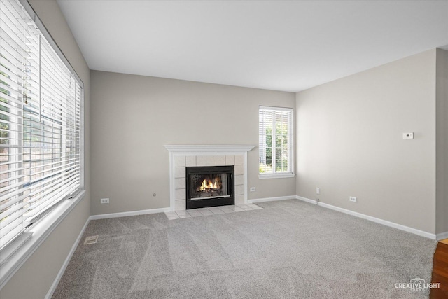 1207 Pennsbury Ln, Aurora, IL 60502 - unfurnished living room featuring a tile fireplace, baseboards, and light colored carpet
