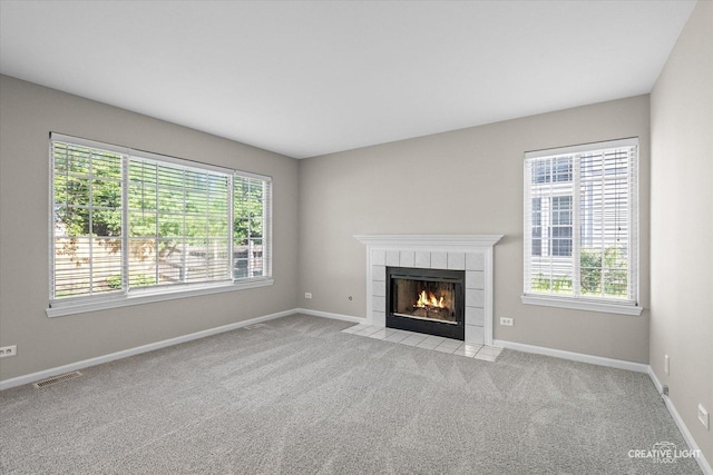 1207 Pennsbury Ln, Aurora, IL 60502 - unfurnished living room with healthy amount of natural light, a fireplace, baseboards, and light carpet