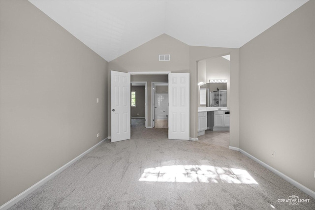 1207 Pennsbury Ln, Aurora, IL 60502 - unfurnished bedroom with light colored carpet, vaulted ceiling, ensuite bath, and baseboards