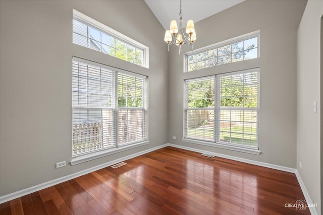 1207 Pennsbury Ln, Aurora, IL 60502 - spare room featuring a chandelier, hardwood / wood-style floors, healthy amount of natural light, baseboards, and high vaulted ceiling