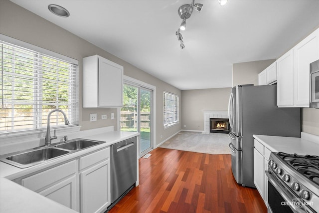1207 Pennsbury Ln, Aurora, IL 60502 - kitchen with stainless steel appliances, a sink, light countertops, white cabinets, and dark wood-type flooring