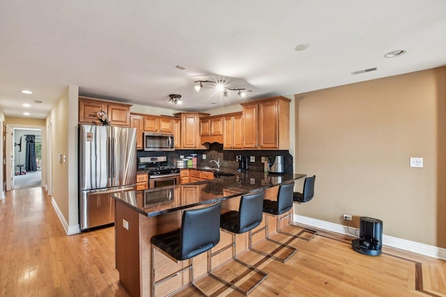 5652 W 63rd St Unit 3E, Chicago, IL 60638 - kitchen featuring light wood-style flooring, stainless steel appliances, baseboards, a peninsula, and backsplash